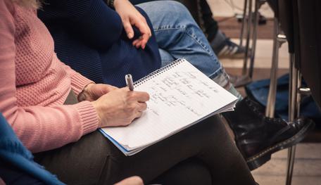 A staff member taking notes during a meeting.