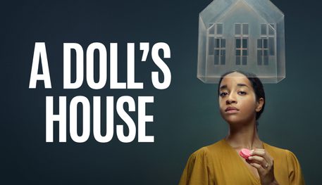 Against a dark grey background, text reads: A DOLL'S HOUSE in white. To the right of the text a person in a mustard coloured dress looks in to the camera. They are holding a small pink macaroon. A translucent structure of a house is suspended above their head.