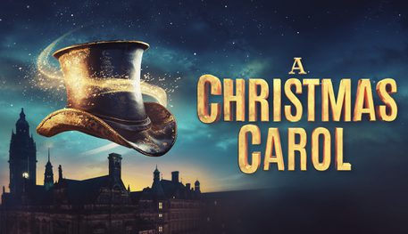 A night sky at dusk with the silhouette of Sheffield's town hall building. In the foreground, a black Victorian top hat floats, swirled with a golden sparkly light. Text reads: A CHRISTMAS CAROL