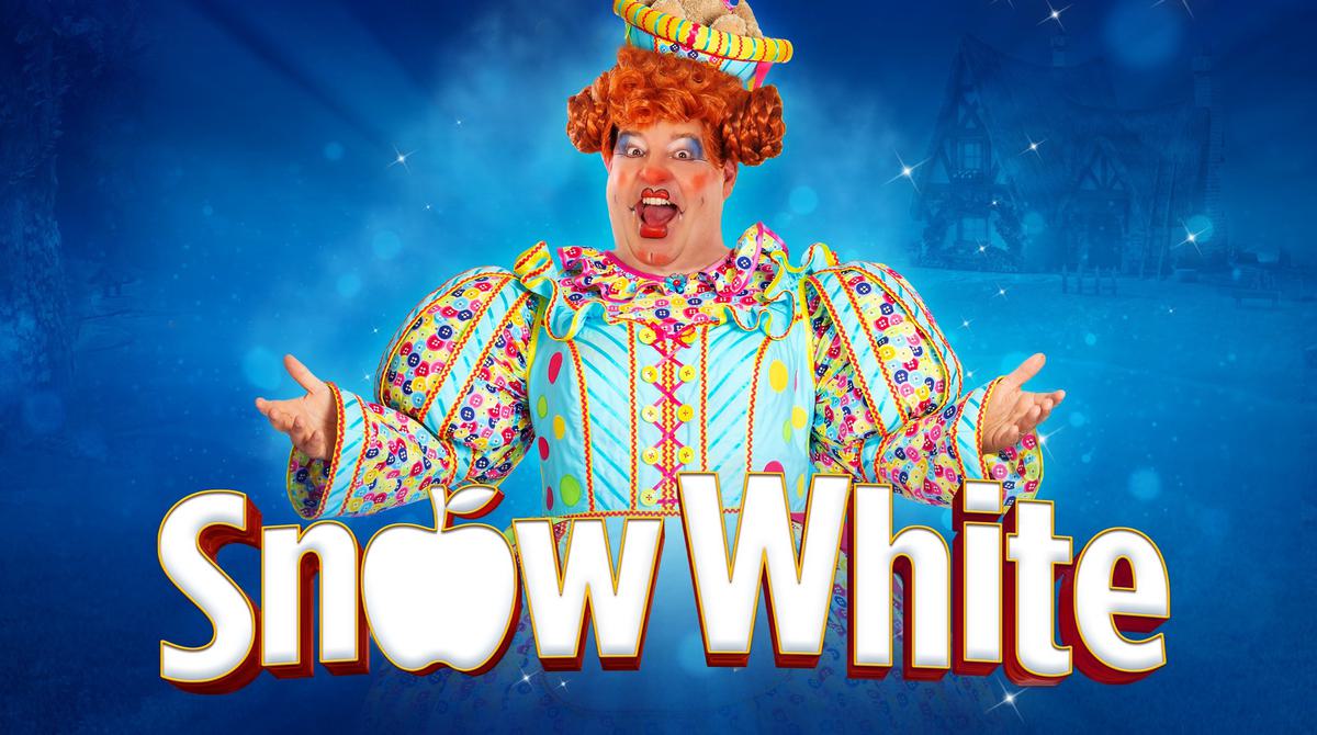 Promotional artwork for the 2024 Lyceum pantomime Snow White. Damian Williams as the dame in front of a blue background wearing a corseted dress covered in a multi-coloured button pattern. She opens her arms in a welcoming pose. Title reads Snow White in a white font with the letter O replaced with an apple.