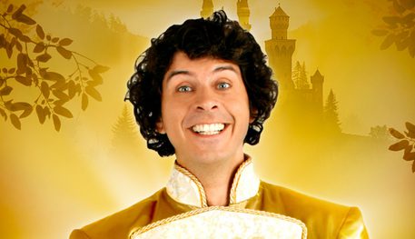 Against a gold backdrop, a person with black curly hair smiles and holds out a silver show on a red, velvet cushion. Text reads: CINDERELLA