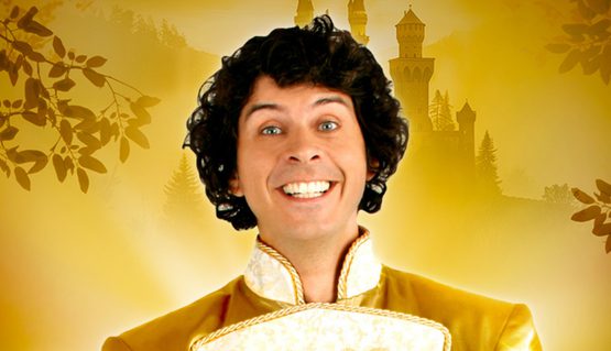 Against a gold backdrop, a person with black curly hair smiles and holds out a silver show on a red, velvet cushion. Text reads: CINDERELLA