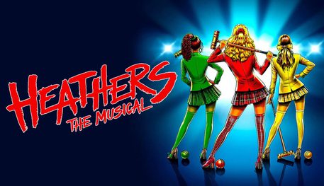 Promotional image for Heathers featuring an illustration of three girls, all facing away from the camera. On the left there is a girl holding a green croquet mallet. She is wearing a green fitted blazer and a short skirt. She has black mid length hair. In the middle there is a girl wearing a red fitted blazer and a red chequered short skirt. She has long wavy blonde hair. She is holding a red croquet mallet. On the right there is another blonde woman. She is wearing a yellow fitted blazer and yellow and white striped short skirt.. She has shoulder length wavy hair. She is also holding a yellow croquet mallet. There is a croquet ball by each of their feet.