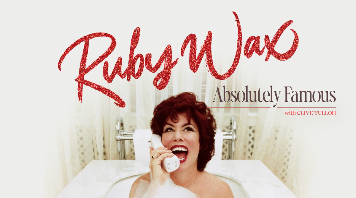 Promotional image featuring Ruby Wax smiling while laying in a bubble bath holding a white cordless landline phone.