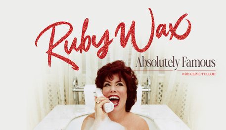 Promotional image featuring Ruby Wax smiling while laying in a bubble bath holding a white cordless landline phone.