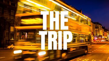 Promotional image for the trip featuring an out of focus bus travelling down a street at night time.