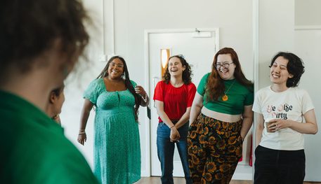 Local artists standing in a line smiling as part of a huddle circle.