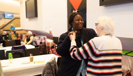 Two people dance and smile in the foyer of the Crucible theatre