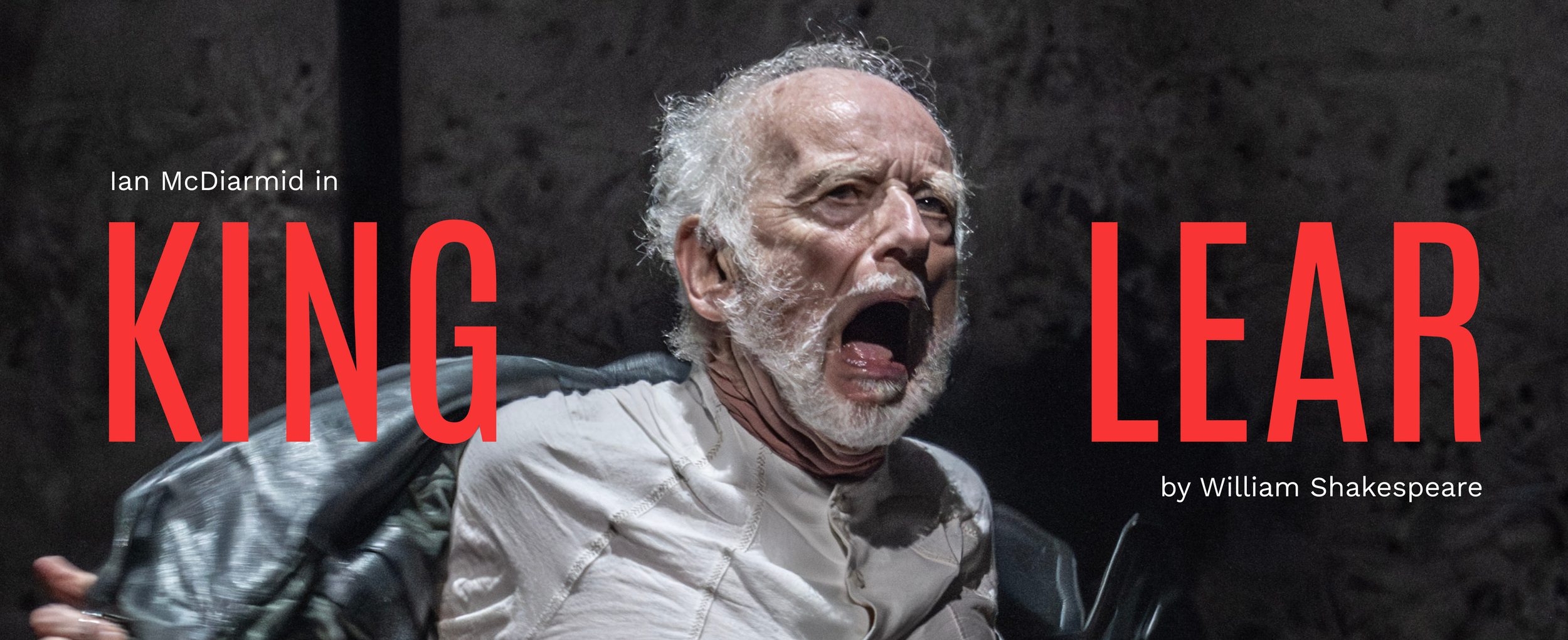 Ian McDiarmid (King Lear) in King Lear. Photo by Johan Persson. An older person with a white beard wears a long leather coat and shouts, ripping off their coat.