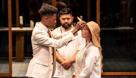 Claire Wetherall (Hero) and Richard Peralta (Friar) in Much Ado About Nothing. Photo by Johan Persson. The two actors press their foreheads together in comfort and hold each other close. They both seem to have been crying.