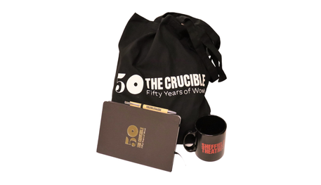 A black tote bag and notebook that say The Crucible - Fifty Years of Wow. Plus a Sheffield Theatres pen and mug.