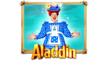 Damian Williams dressed in a blue dame dress with a white apron holds their arms out and smiles. They are in a gold frame with gold text reading: ALADDIN