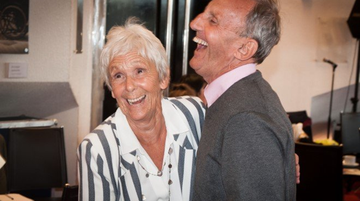 An elderly couple dance and smile in the Crucible foyer at a Tea Dance